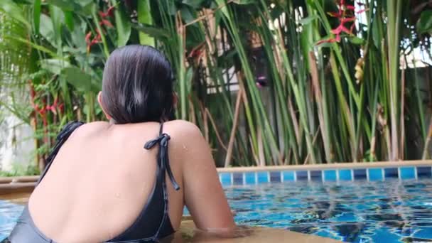 プールでリラックスした若い女性のバックビュー - 映像、動画