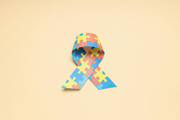 Stuha s mnoha barevnými puzzle kousky na světlém pozadí. Koncept Světového dne autismu - Fotografie, Obrázek