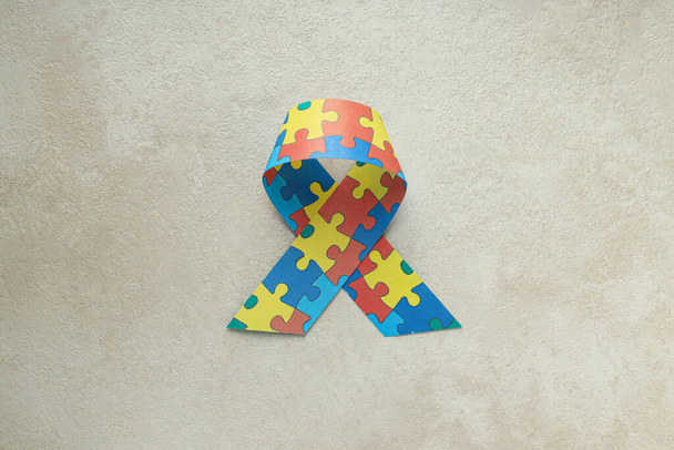 明るい背景に多色のパズルが付いているリボン. 世界自閉症デーコンセプト - 写真・画像