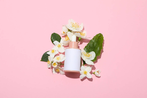 Jasmine flowers and cosmetic bottle on pink background, top view - Photo, Image