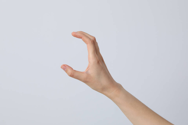 Ženská ruka je natažená na světlém pozadí - Fotografie, Obrázek
