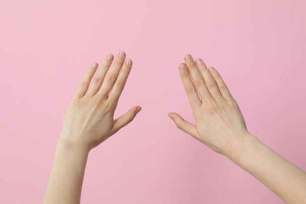 Naisen kädet vaaleanpunaisella taustalla - Valokuva, kuva