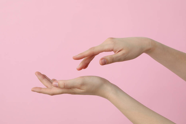 Mani femminili su uno sfondo rosa chiaro - Foto, immagini
