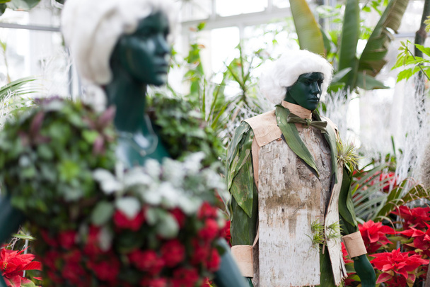 アラン ガーデンズ、トロント、オンタリオ州、カナダに表示されるカラフルなクリスマスの花で作られた服を着ての彫像 - 写真・画像