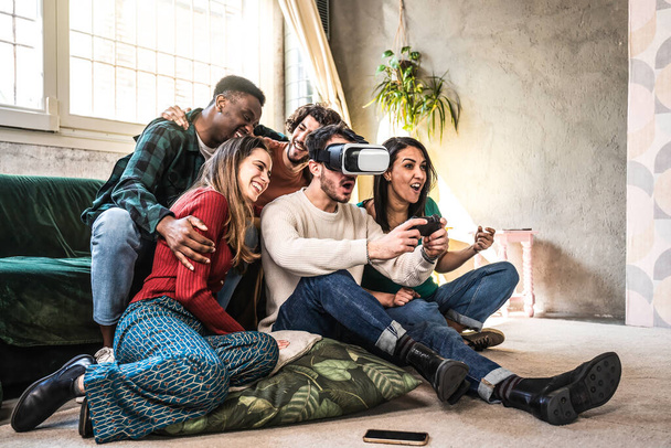 Onnellisia monikansallisia ystäviä sohvalla pelaamassa videopelejä VR 3d katsoja kotona - Iloinen sukupolvi z ryhmä hauskaa modernin teknologian videopelejä - Hobby ja tech käsite - Valokuva, kuva