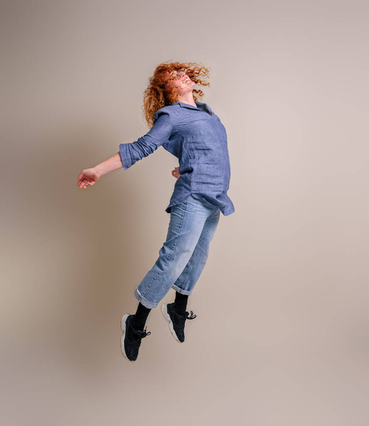 Jovem empresária alegre com braços estendidos pulando e celebrando contra o fundo - Foto, Imagem