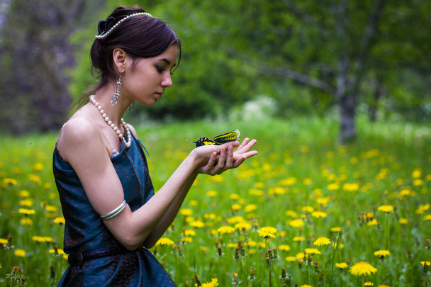 the girl in the dandelions holding a butterfly - Фото, изображение
