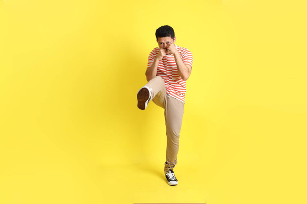 O homem asiático adulto em roupas casuais em pé sobre o fundo amarelo. - Foto, Imagem