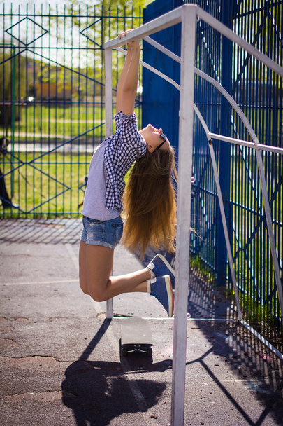 cute girl in shorts with a skateboard on the Playground - Photo, Image