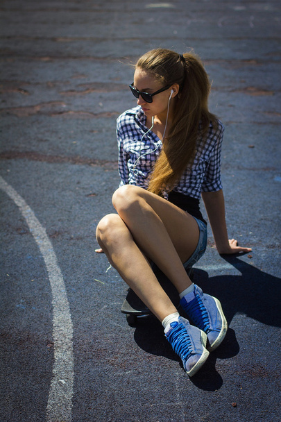 cute girl in shorts with a skateboard on the Playground - Photo, image