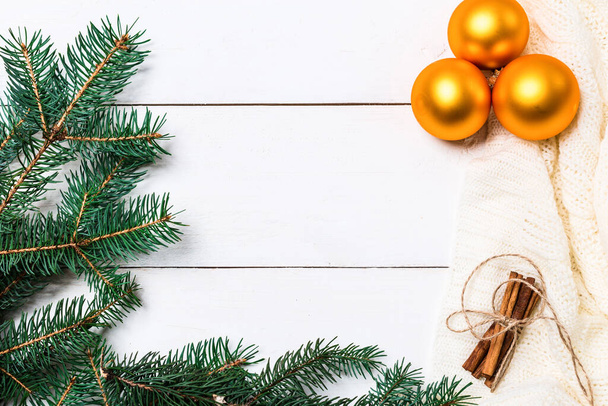 Різдвяна композиція. в'язана ковдра, соснові шишки, ялинкові гілки на дерев'яному білому тлі. Плоский прошарок, вид зверху - Фото, зображення