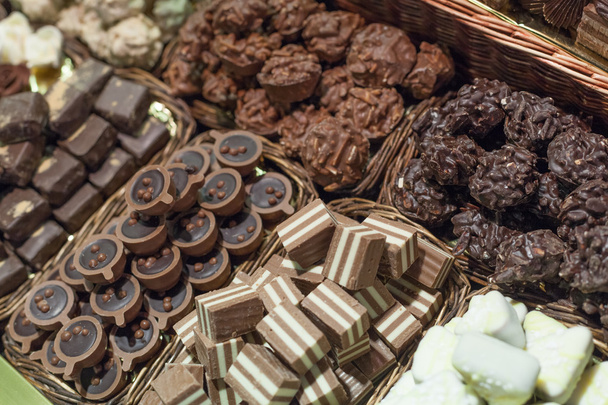 Разнообразие шоколадных конфет в ларьке
 - Фото, изображение