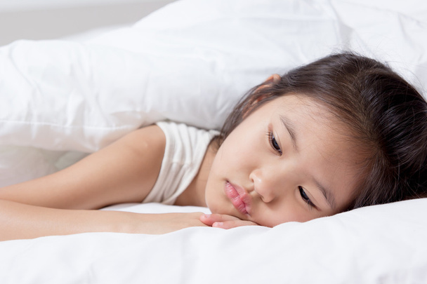 Petit enfant asiatique couché sur le lit
 - Photo, image