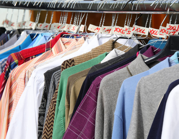 использованная одежда и новые платья в киоске на блошином рынке - Фото, изображение