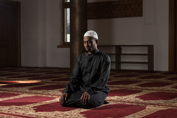 El hombre musulmán africano reza en la mezquita
 - Foto, imagen