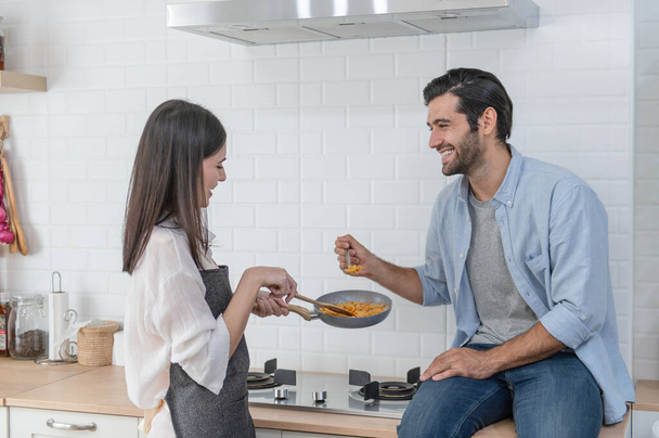 Boldog fiatal pár főz együtt a konyhapulton otthon - Fotó, kép