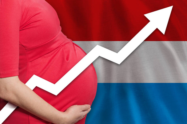 Foto de mulher grávida na bandeira do Grão-Ducado do Luxemburgo. Taxa de natalidade - Foto, Imagem