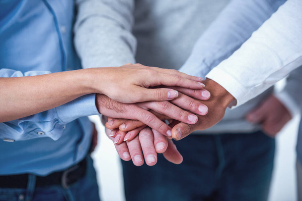 Cropped image of beautiful business people in smart casual wear holding hands together - Photo, Image