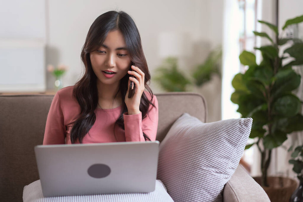 Frauen reden auf dem Smartphone und tippen Geschäftsdaten auf dem Laptop, während sie zu Hause im Lebensstil arbeiten. - Foto, Bild