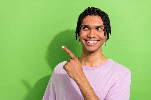 Photo of youngster guy wearing hair cornrows directing finger empty space ad adv ads hair salon isolated green color background. - Foto, afbeelding