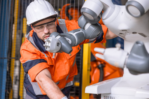 profesionální inženýr robot technik muž pracovní kontrola služby předem vysoce přesné robot rameno sběrač v automatizaci továrny - Fotografie, Obrázek
