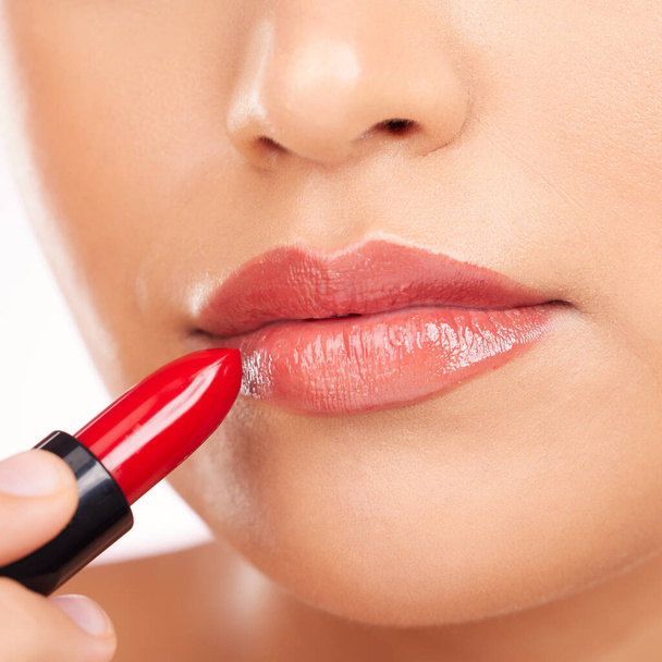 Beauty, makeup and woman with lipstick on a white background for cosmetics, skincare products and salon. Fashion, aesthetic and mouth closeup of person in studio for cosmetology, glamour or red gloss. - 写真・画像