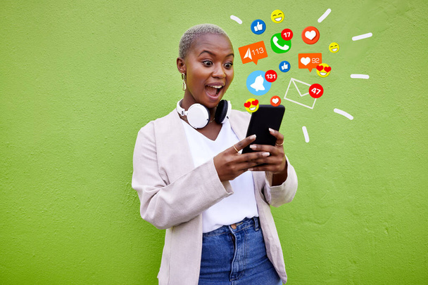 Surprise, black woman and reading phone emojis, social media icons and wow facial expression for networking notification. App opinion, cellphone communication or shocked user on green background wall. - Photo, Image