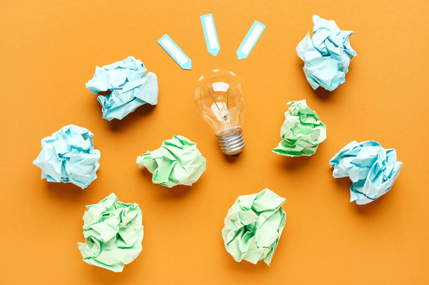 Light bulb with crumpled paper on color background. Logic concept - Photo, Image