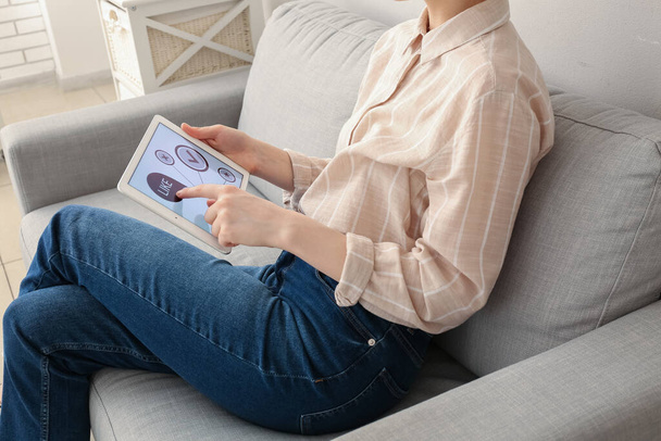 Mujer con Tablet PC que toma la experiencia de la encuesta en el sofá en casa, primer plano - Foto, imagen