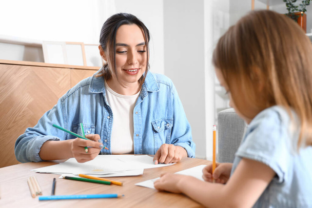Mladá žena se svou dcerou kreslit doma - Fotografie, Obrázek