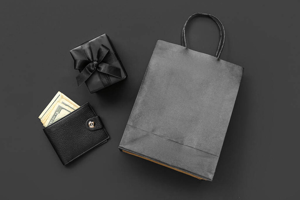 Torba na zakupy, pudełko i portfel z pieniędzmi na czarnym tle. Koncepcja Black Friday - Zdjęcie, obraz