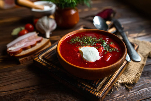 Hagyományos ukrán borscsot. Egy tál vörös cékla leves borsch fehér krémmel. Répagyökér ízletes leves. Hagyományos ukrajnai élelmiszer-konyha. - Fotó, kép