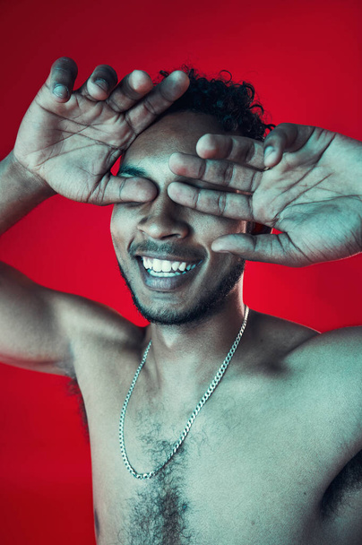 Man, hands and cover eyes in studio, smile and topless for body health and wellness on red background. Skin, person and aesthetic for cosmetics, skincare and healthcare with muscles and happy. - Фото, зображення