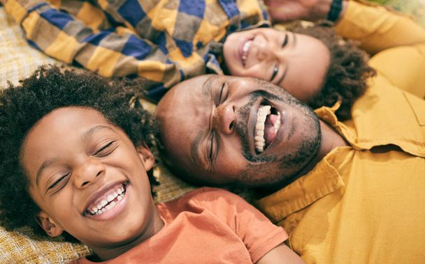Happy family, children and face of man with relax, smile and happiness from above on floor, love and eyes closed for bond. Black people, care and quality time in house or home for bonding together. - Photo, image