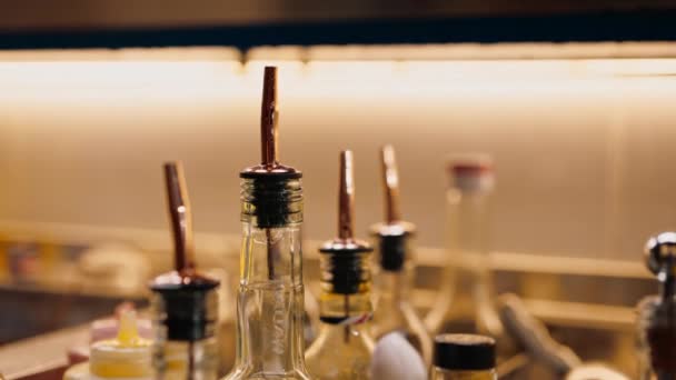 lähikuva monista alkoholipulloista baarilaitteissa cocktailpullojen valmistukseen - Materiaali, video
