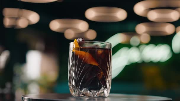 świeżo przygotowany czarny koktajl alkoholowy obraca się na blacie baru w barze - Materiał filmowy, wideo