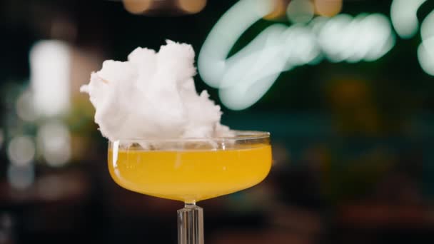 cóctel alcohólico sabroso fresco con algodón de azúcar gira en el mostrador del bar en el bar o restaurante - Imágenes, Vídeo