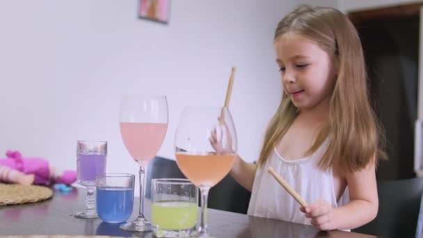 Niña, niño pequeño toca música con muslos en vasos de agua en la cocina. Foto de alta calidad - Imágenes, Vídeo