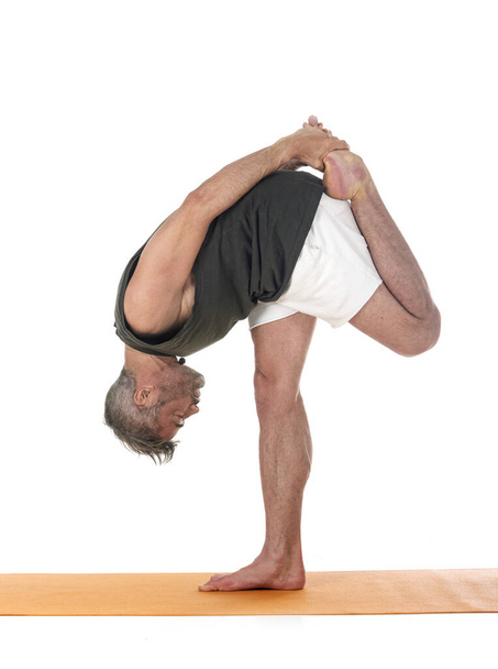 uomo e hatha yoga asana di fronte a sfondo bianco - Foto, immagini