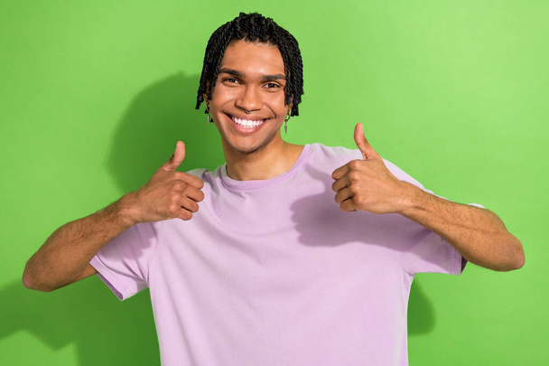 Portrait of funny youngster guy raising thumbs up recommending approving put social like isolated green color background. - Foto, immagini