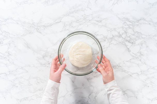 Flat lay. Mixing ingredients in a large glass mixing bowl to make homemade royal icing. - Photo, Image