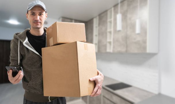 Hombre levantar cajas de cartón en el interior del apartamento - Foto, Imagen