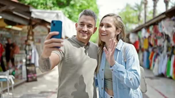 Férfi és nő pár mosolyog magabiztos birtoklás video hívás az utcán piacon - Felvétel, videó
