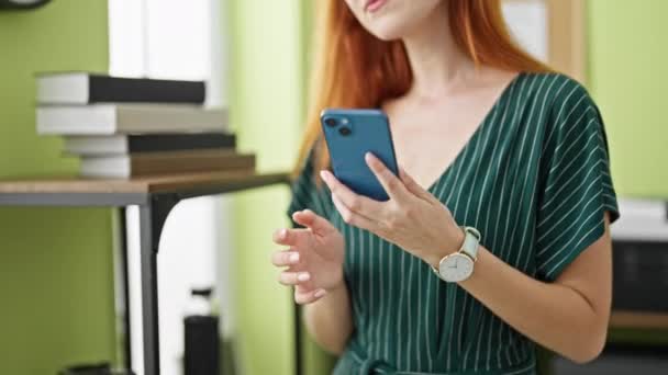 Young redhead woman business worker talking on smartphone working at office - Footage, Video