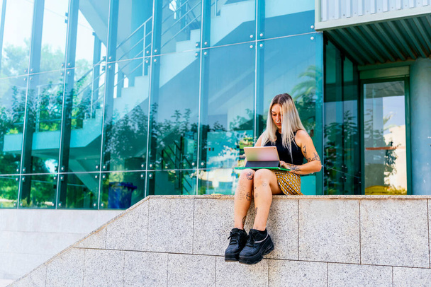 Современный студент колледжа с ноутбуком в офисном здании. - Фото, изображение