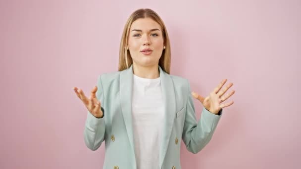Nuori blondi nainen liiketoiminnan työntekijä hymyilee luottavainen puhuu yli eristetty vaaleanpunainen tausta - Materiaali, video