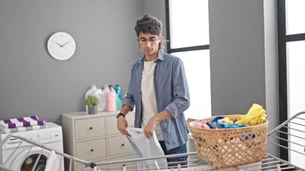 Молодий іспаномовний чоловік вішає одяг на білизні в пральні
 - Кадри, відео