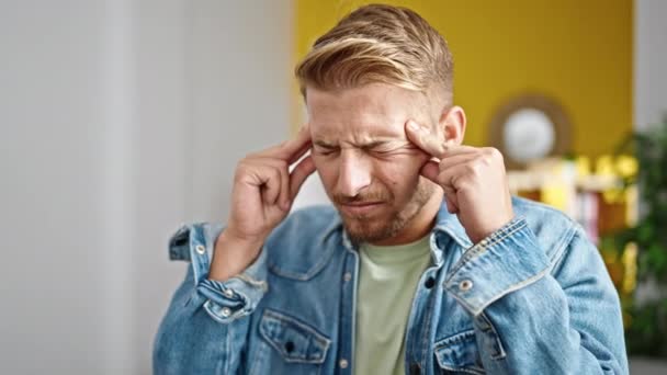 Joven hombre caucásico que sufre de dolor de cabeza en casa - Imágenes, Vídeo