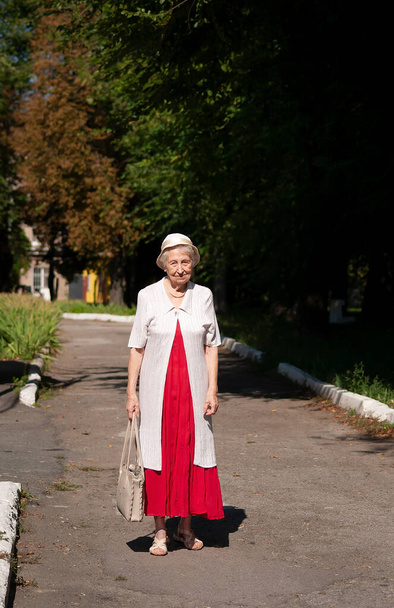 Portrait d'une femme âgée souriante. Une photo sur le fond du parc naturel - Photo, image