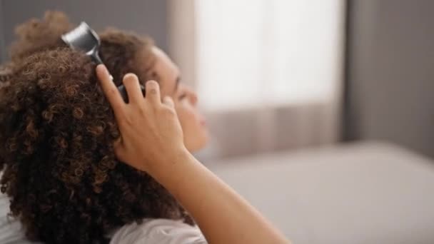 Mladý krásný hispánský žena poslech hudby uvolněný na pohovce doma - Záběry, video